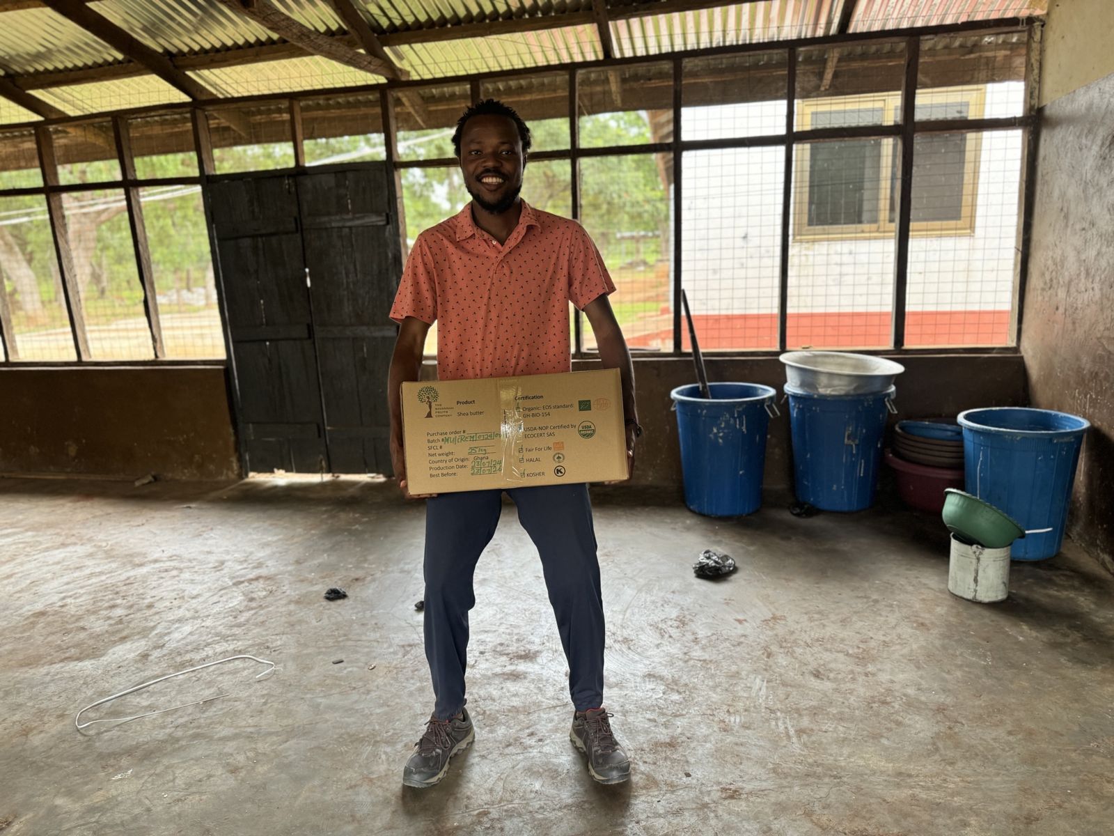 Samuel holding a 25 kg box of shea butter